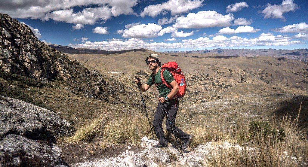 Lars Fjendbo Møller med et par lette vandresko og vandrestave, i bjergterræn i Peru. Foto: Anker Bak.